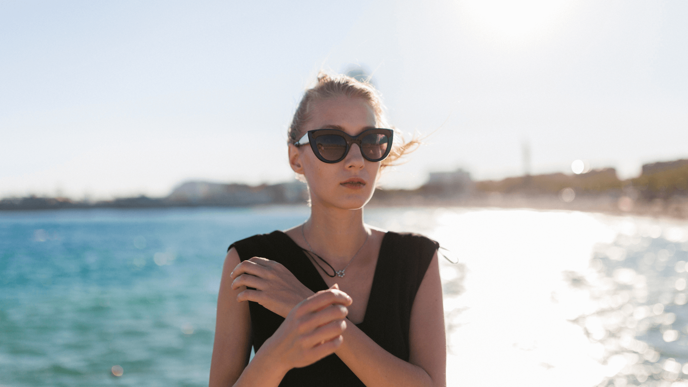 A woman protecting her eyes with sunglasses from sun damage to prevent macular degeneration