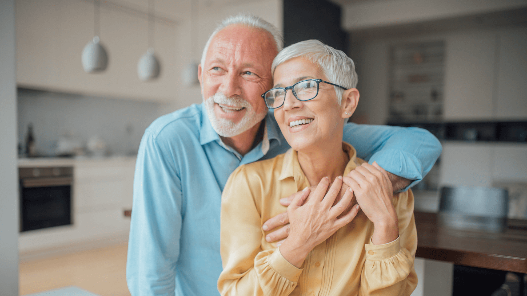 An older couple smiling, representing healthy aging and the importance of proactive eye care to prevent conditions like age-related macular degeneration.