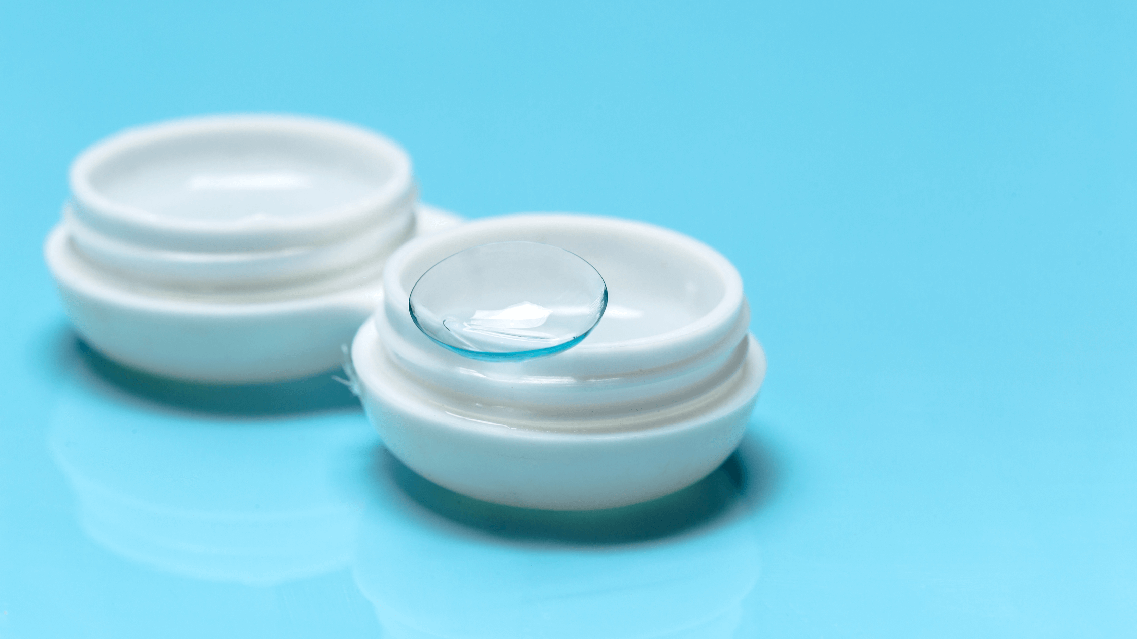 A close-up image of a specialty contact lens resting on a finger, highlighting the lens's design for use in Scleral lenses and dry eye treatment.