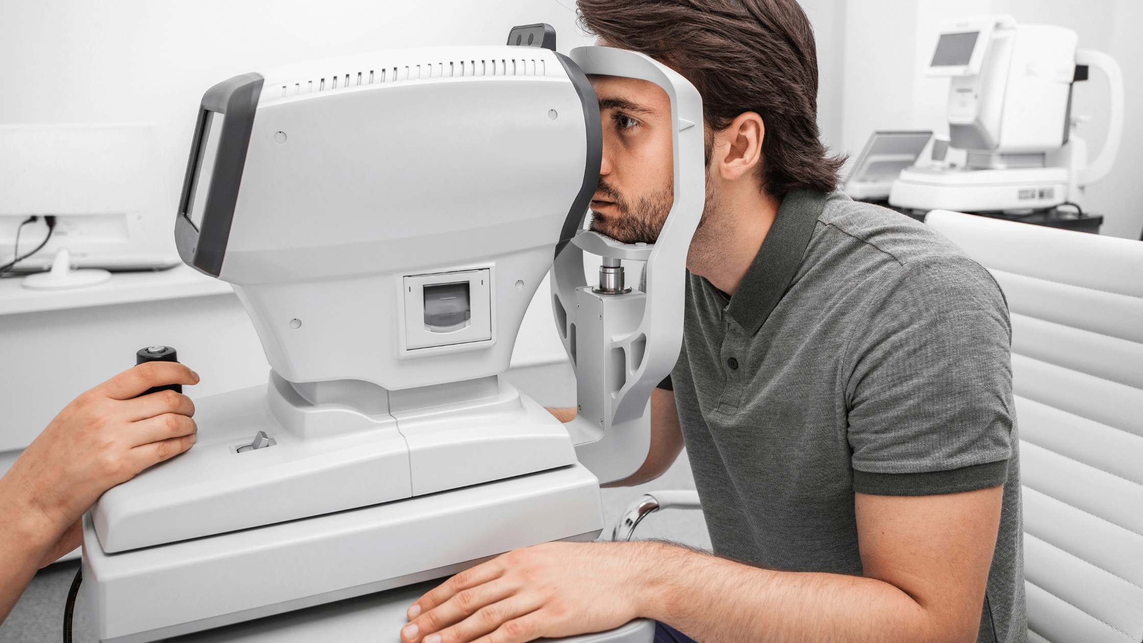 A patient leaning into an optical machine (autorefractors), representing a comprehensive eye exam and the use of FSA or HSA funds for the procedure.