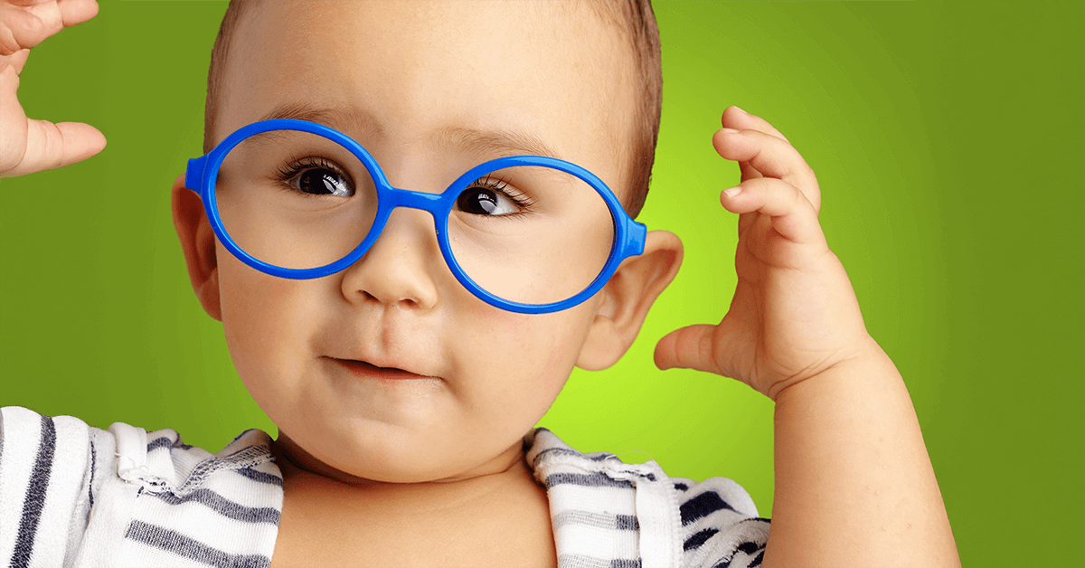 A close-up of a baby wearing large, round blue training glasses, symbolizing the need for early and regular child eye exams starting in infancy.